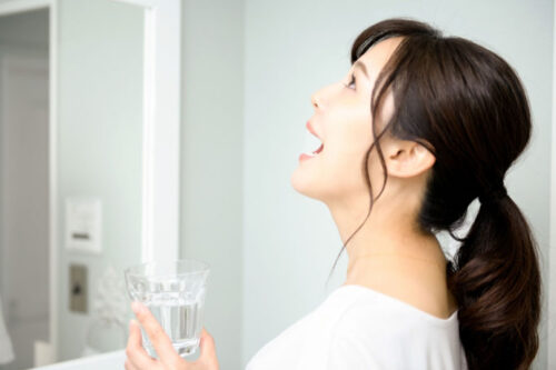 洗面所でうがいをする女性 口腔内を清潔に保つ習慣 歯科医院推奨ケア